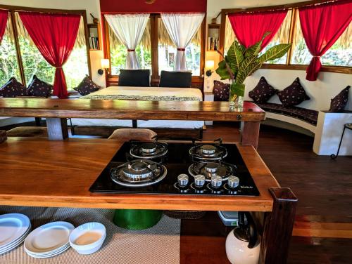 a living room with a stove with dishes on a table at Framadani estate - Villa with a pool and Or thatch roof Cabin in San Ignacio