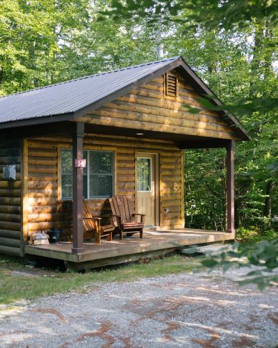 a log cabin with two chairs on a deck at Sterling Ridge Resort in Jeffersonville