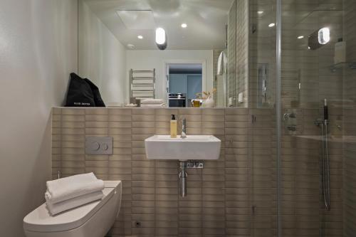 a bathroom with a sink and a toilet and a shower at Unity Hammarby Sjöstad - A Studio Hotel in Stockholm
