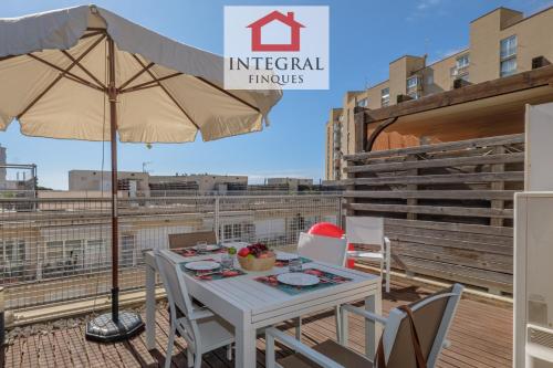 a patio with an umbrella and a table and chairs at Apartament Terra de Mar in Palamós