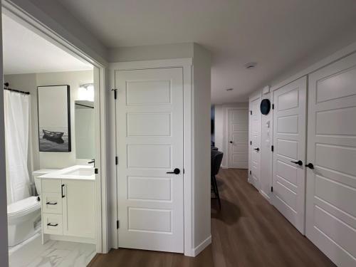 baño con puerta blanca y lavamanos en Cozy 2 bedrooms Suite Near Calgary Airport Sleeps 6, en Calgary