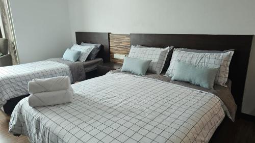 a bedroom with two beds with blue pillows at KITA Studio - Kota Bharu City Point in Kota Bharu