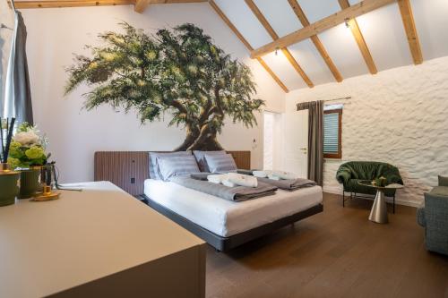 a bedroom with a bed with a tree on the wall at Aurora Lukorana in Lukoran
