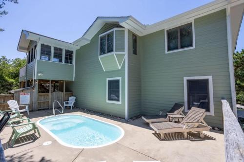 een huis met een zwembad ervoor bij Pool Hot Tub Beach Gear included in Corolla