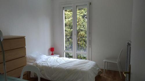 une chambre avec un lit et une grande fenêtre dans l'établissement Agréable appartement Montfavet Avignon, à Avignon