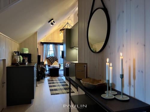 Una cocina con una encimera con dos velas y un espejo. en Lindvallen Ski Resort Pool and Padel - Sauna - 7 Guests, en Sälen