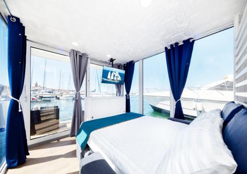 阿尔盖罗Alghero houseboat Blue Zone的船上的卧室,带床和窗户