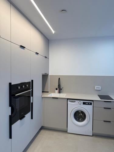 a kitchen with a washing machine and a sink at ירדן דירת גן אדריכלית סוויטה פרטית in Eilat