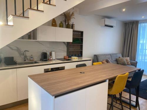 une cuisine avec des placards blancs et un îlot de cuisine avec des chaises jaunes dans l'établissement Appartement 3, aux Lilas