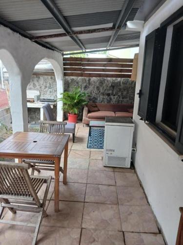 a patio with a table and chairs and a couch at Villa des Filaos et du lagon o6, 93 , 70 , 59 , 79 in Saint-Leu