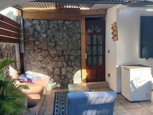 a living room with a stone wall and a door at Villa des Filaos et du lagon o6, 93 , 70 , 59 , 79 in Saint-Leu