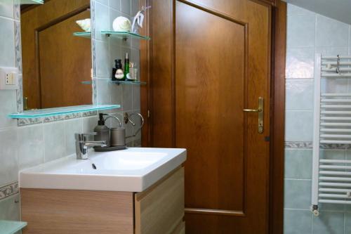 a bathroom with a sink and a wooden door at A Casa di Lu' Elegant Rooms in Monterotondo