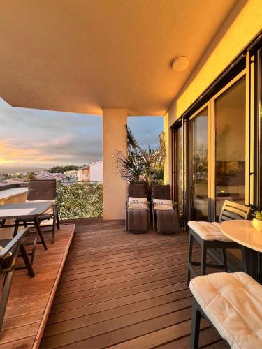 a wooden deck with tables and chairs on a balcony at Lux -Luxury Sea and Mountains View Apartment-NEW in Koper
