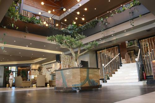 a lobby with a tree in the middle of a building at Anthidon Nature Estate & Farm in Chalkida