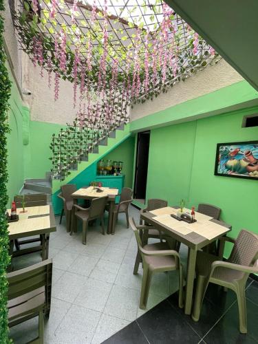 a restaurant with tables and chairs and a ceiling with flowers at Hotel boutique San Pablo H10 in Medellín