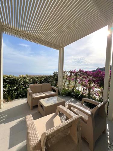a patio with chairs and tables and a large umbrella at TIS, Green Coast in Palasë
