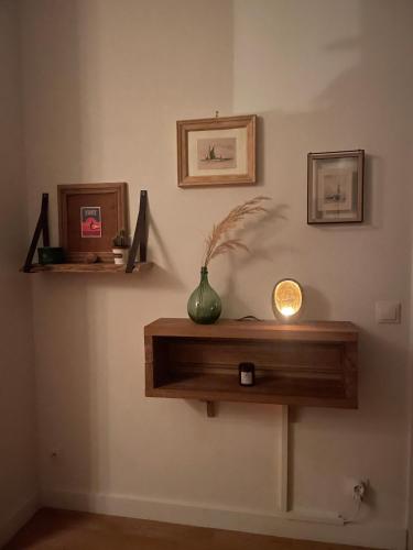 une étagère sur un mur avec un vase sur lui dans l'établissement Le Cosy Tête d Or Cité Internationale, à Caluire-et-Cuire