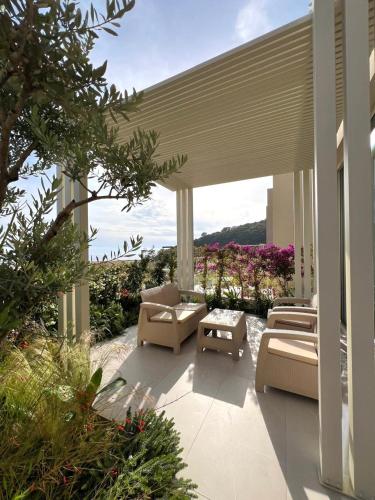 a patio with couches and chairs on a house at TIS, Green Coast in Palasë