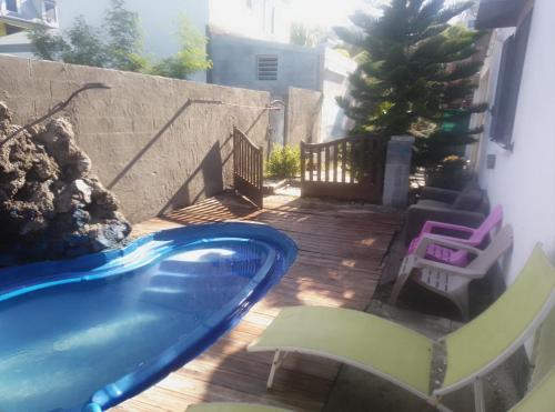 a swimming pool in a backyard with a deck at Villa des Filaos et du lagon o6, 93 , 70 , 59 , 79 in Saint-Leu