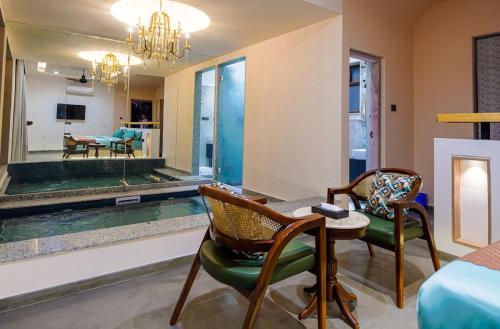 a room with a pool and two chairs and a table at Eraaya Farms Luxury Pet Friendly Villa with Pool in Dabok