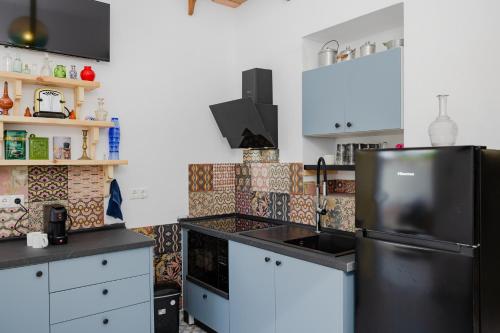 a kitchen with a black refrigerator and white cabinets at Pefkos Eye in Pefki Rhodes