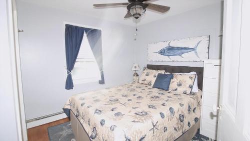 una camera da letto con un letto con un disegno di pesce sul muro di The Daisy Cottage- 1St Floor Unit a Cape May