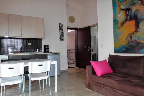 a kitchen with a couch and a table and chairs at Yasoo Holiday Apartments in Olympiada