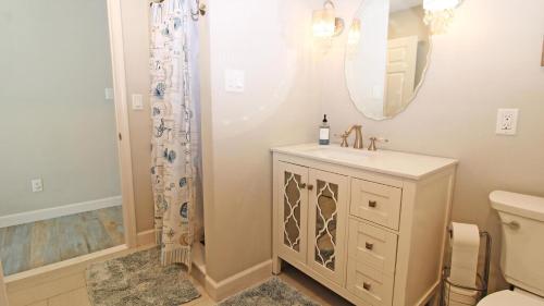 Un baño con lavabo, espejo e inodoro. en Sunswept - Pet Friendly!, en North Cape May