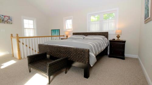 a bedroom with a large bed and a chair at Ca De Cha in West Cape May