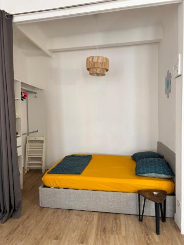 - une chambre avec un lit jaune dans l'établissement La plaine - T1BIS- Clim, à Marseille