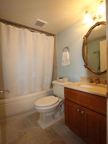 a bathroom with a toilet and a sink and a mirror at Broadway Beach Retreat Unit 4 in Cape May