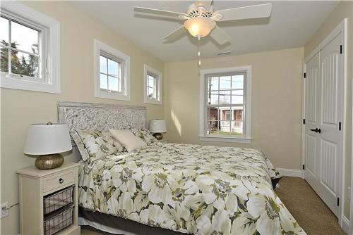 una camera da letto con un letto e un ventilatore a soffitto di Congress Cottage a Cape May