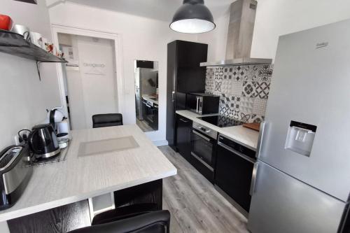 une cuisine avec un réfrigérateur et un plan de travail dans l'établissement Le Balcon du Port- private parking, à Aix-les-Bains