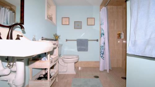 Un baño con lavabo, inodoro y ducha. en Broadway Beach Unit 3, en Cape May