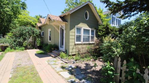 a small green house with a fence at Cottage On Cambridge in Cape May Point