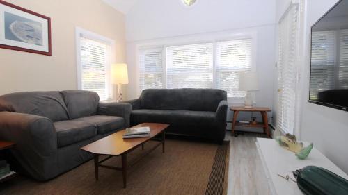 a living room with a couch and a table at Cottage On Cambridge in Cape May Point