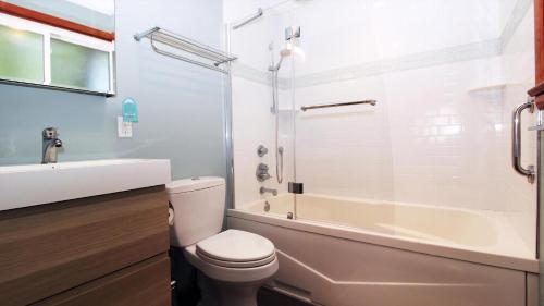 a bathroom with a toilet and a tub and a sink at Cottage On Cambridge in Cape May Point