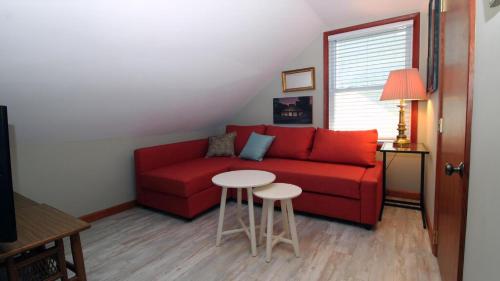 a living room with a red couch and a table at Cottage On Cambridge in Cape May Point