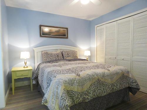 a bedroom with a bed and two lamps on a night stand at Driftwood Condo 15 in Cape May