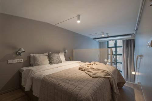 a bedroom with a bed with a blanket on it at Unity Hammarby Sjöstad - A Studio Hotel in Stockholm