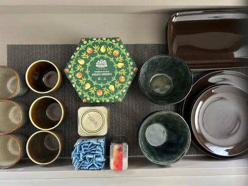 a shelf with bowls and a tie next to a microwave at Cozy STAY in City Center in Telšiai