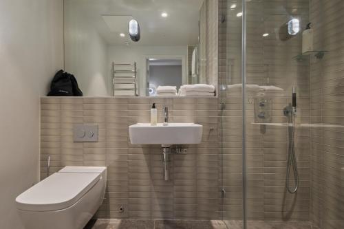 a bathroom with a toilet and a sink and a shower at Unity Hammarby Sjöstad - A Studio Hotel in Stockholm