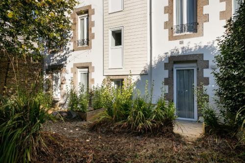 un bâtiment avec une porte et des plantes devant lui dans l'établissement T2 Kouign Amann, à Brest