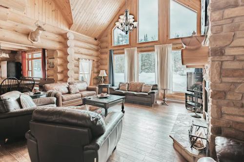 a living room with leather furniture in a log cabin at Ultimate Group Getaway, Private Pool, Spa, Sauna in Mille-Isles