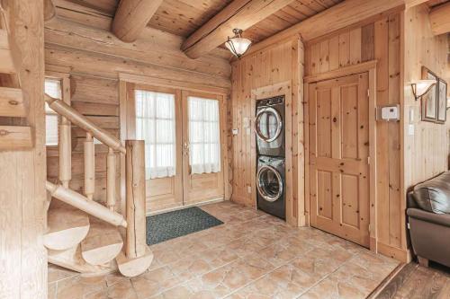 a laundry room with a washer and dryer in a log cabin at Ultimate Group Getaway, Private Pool, Spa, Sauna in Mille-Isles