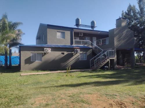 a house with a staircase leading up to it at Cabañas y Bungalow " La Comarca" in Concepción del Uruguay