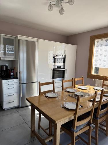 une cuisine avec une table en bois et un réfrigérateur dans l'établissement Le Sonise - Spacious family apartment with balcony garden and parking spac, à Aix-les-Bains