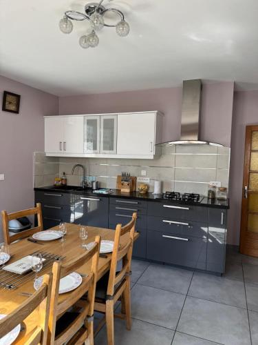une cuisine avec une table en bois et une salle à manger dans l'établissement Le Sonise - Spacious family apartment with balcony garden and parking spac, à Aix-les-Bains