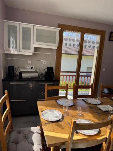 Il dispose d'une cuisine et d'une table à manger avec 4 chaises. dans l'établissement Le Sonise - Spacious family apartment with balcony garden and parking spac, à Aix-les-Bains