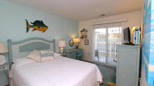Un dormitorio con una cama y un televisor. en Capers302, en Cape May